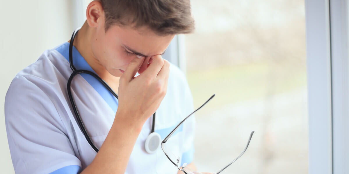 Enfermero experimentando síntomas de ansiedad Enfermero experimentando síntomas de ansiedad